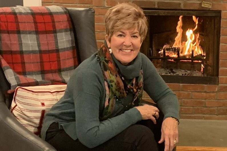 Artist Alice Lieb at home in front of fireplace